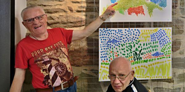 Bild zeigt zwei Personen vor Bildern der Ausstellung Hexenturm Zeil