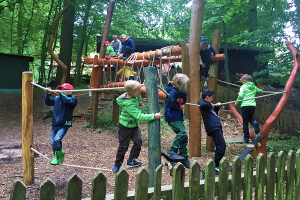 Viel Spaß bei inklusiver Waldwoche - Kinder auf Kletterseilen im Wald