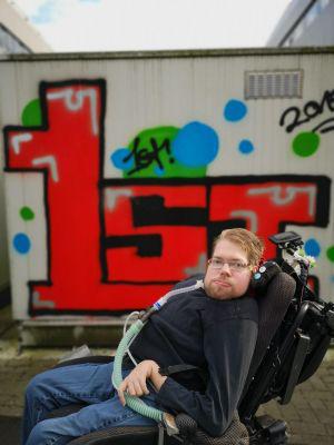 Tim Melkert mit Beatmungsgerät im E-Rolli