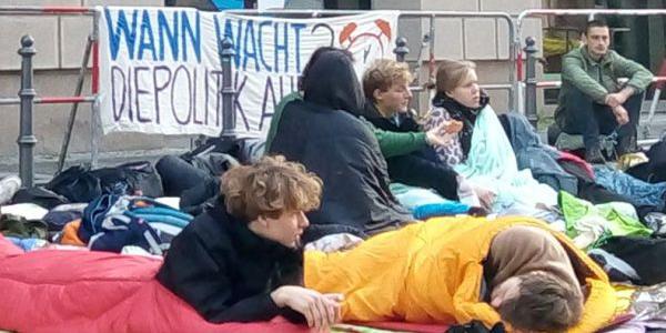 Foto zeigt junge Leute in Schlafsäcken