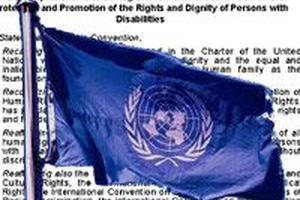 UN-Flagge mit Text Behindertenrechtskonvention im Hintergrund