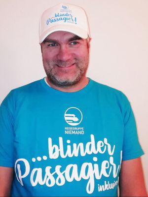 Markus Erlt mit T-Shirt der Reisegruppe Niemand mit der Aufschrift ... blinder Passagier inklusive