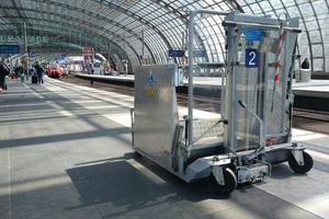 Hublift am Bahnsteig mit einfahrendem Zug