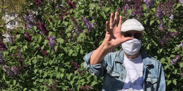 Foto zeigt Autor mit Maske vor einem Fliederbusch