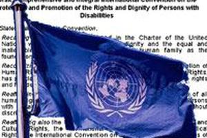 UN-Flagge mit Text Behindertenrechtskonvention im Hintergrund