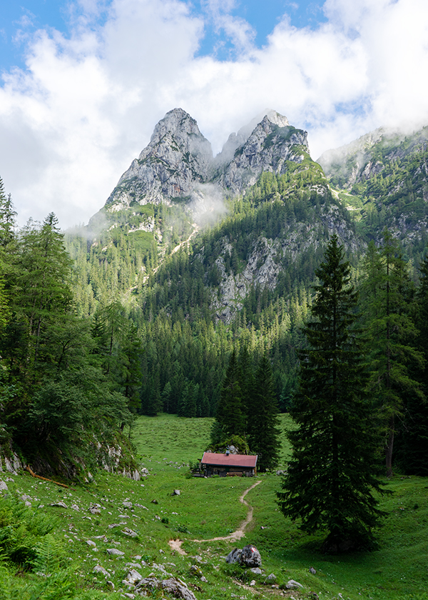 Eine Almhütte steht vor großen Bergen in Saalachtal. Österreich.