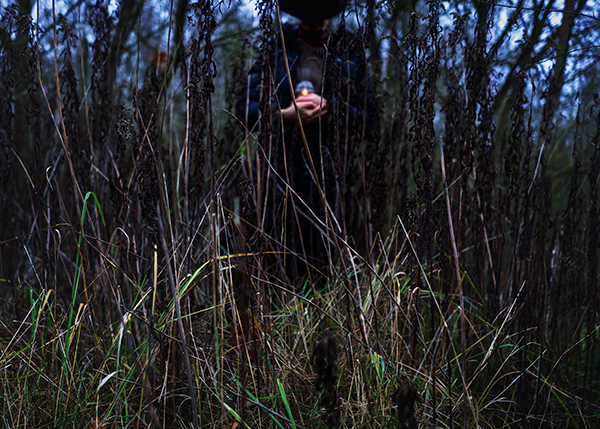 Ein Mensch im Gras mit einer Lampe