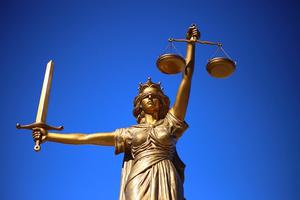 Goldene Statue Justitia mit Schwert und Waage