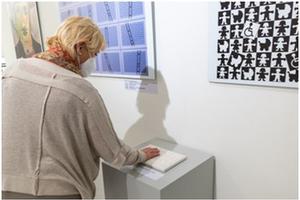 Inklusion im Blick im Foyer des Landtages in Potsdam - Bild zeigt eine Frau an einer tastbaren Tafel