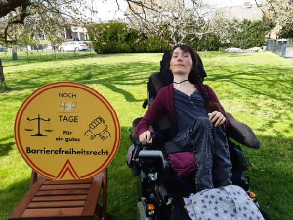 Marleen Soetandi mit Schild: Noch 48 Tage für ein gutes Barrierefreiheitsrecht