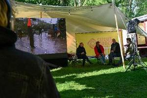 Beim CircusDanceFestival 2021 - Bild zeigt Personen unter einem Zeltdach und Tanzvorführungen auf einem Großbild
