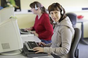 Foto zeigt zwei Frauen am Computer mit Braille-Zeile