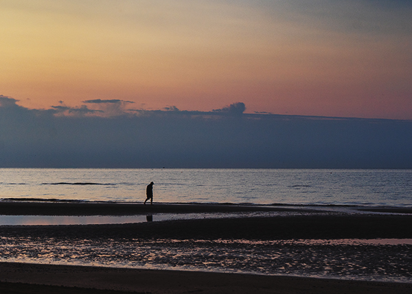 Sonnenaufgang am Mittelmeer. Ein Mensch geht am Strand entlang