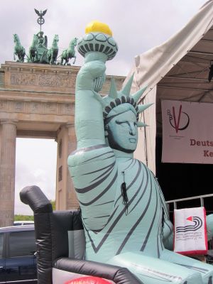 ISL-Fotomontage: Freiheitsstatue im Rollstuhl vor Brandenburger Tor