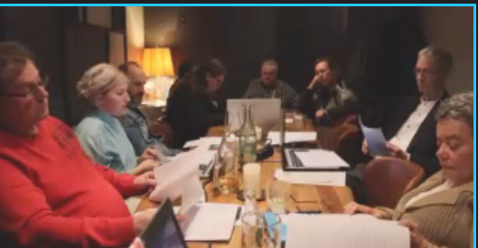 Screenshot der Beratungen - Tisch mit beiderseits sitzenden Personen