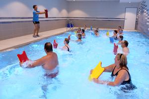 Im Schwimmbecken Menschen mit Reha-Übungen