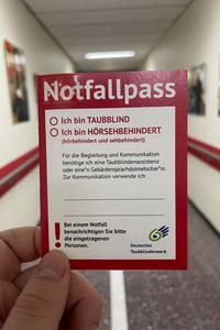 Deckblatt dieses Nothilfepasses in der Hand eines Helfers