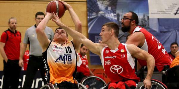 Ausschnitt des Spiels gegen Hannover United - drei Rollstuhlbasketballer im Kampf um den hochgehaltenen Ball