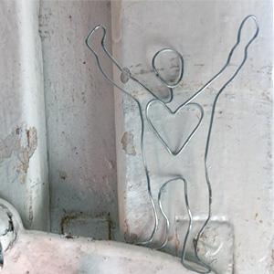 Figur aus Draht mit hochzeigenden Armen