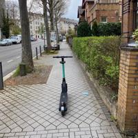 E-Roller, der mitten auf dem Gehweg steht