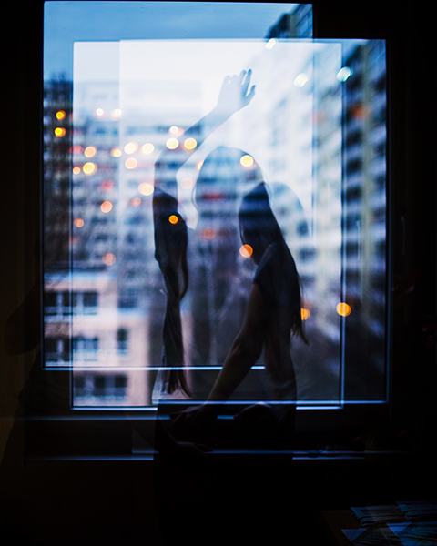Mehrfachbelichtung: eine Person dreimal belichtet gegenüber dem Fenster