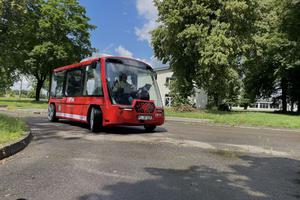 Roter Kleinbus mit einem Fahrer, der das Fahren überwacht