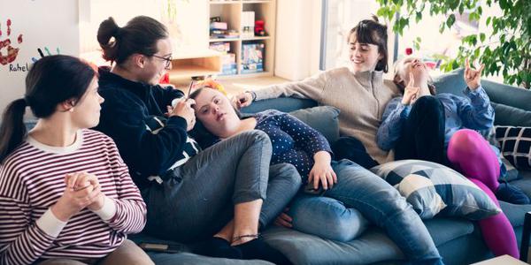 Fünf Mädchen bequem sitzend und liegend auf einer Couch