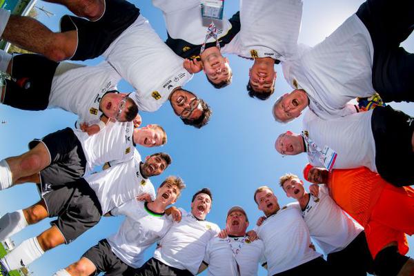 Gruppe von Sportlerinnen und Sportlern im Dress von unten gesehen