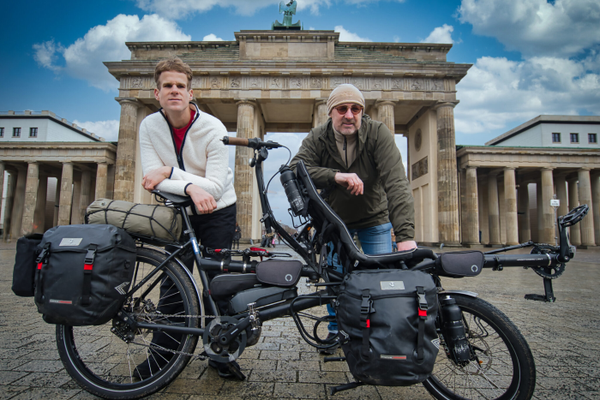 Zwei junge Männer mit ihrem Spezialfahrrad vor dem Brandenburger Tor in Berlin