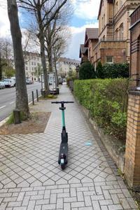 E-Roller, der mitten auf dem Gehweg steht