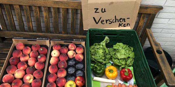 Kisten mit Obst und Gemüse auf einer Bank