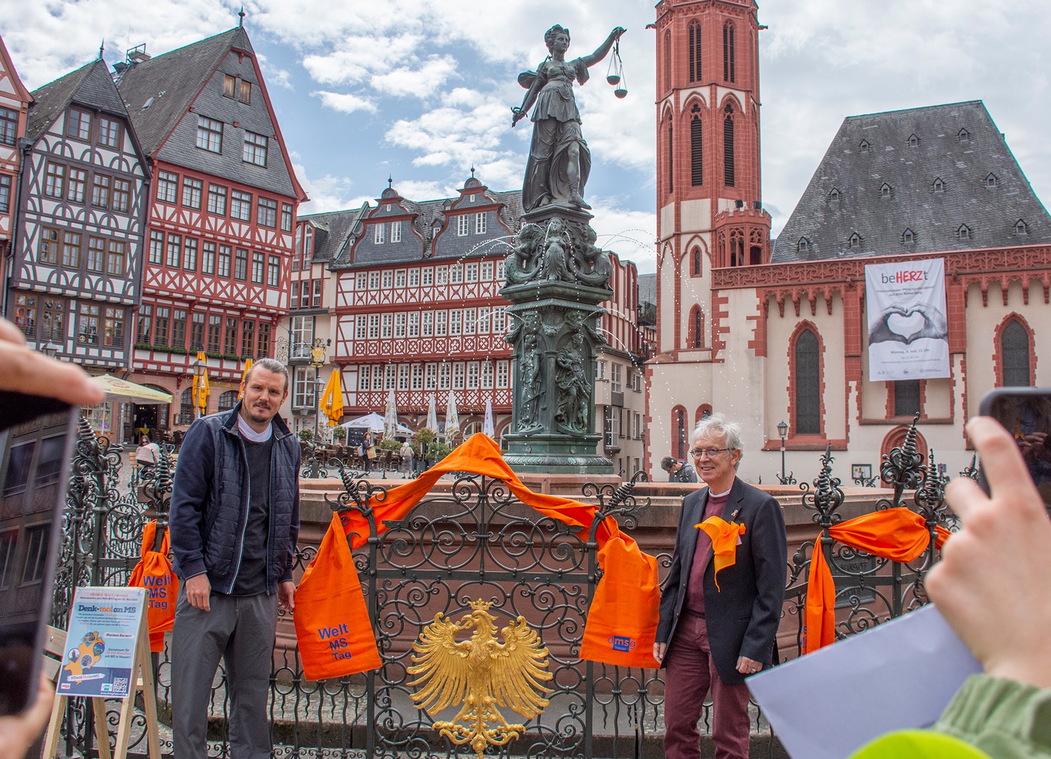 DMSG-Hessen Aktion mit rotem Schal am Brunnen