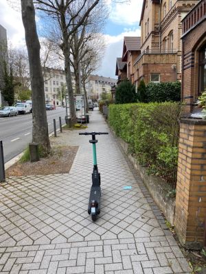 E-Roller, der mitten auf dem Gehweg steht