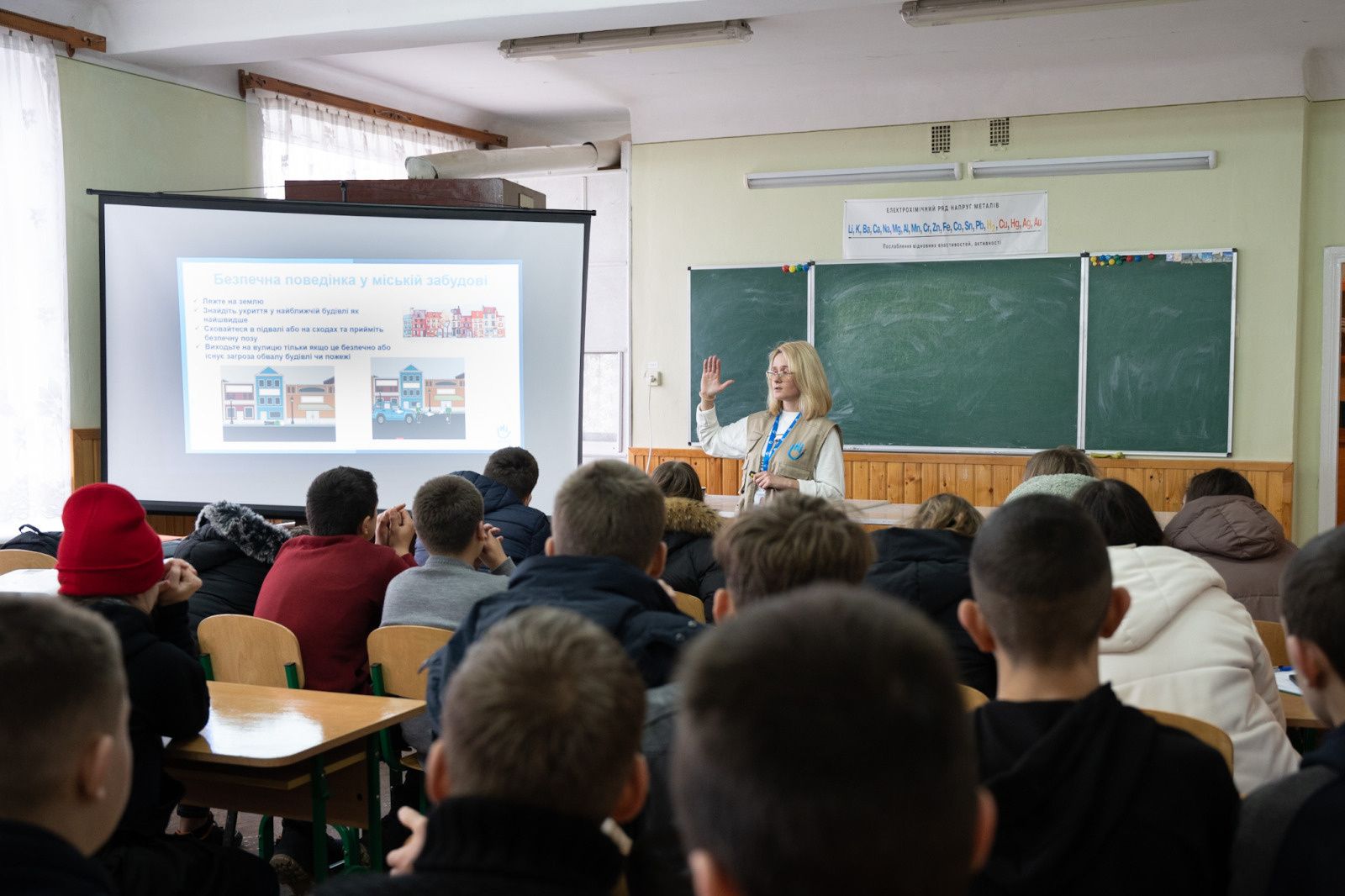 Kinder in einer Schulkasse, an der Wand eine Schultafel und eine Anschuungstafel