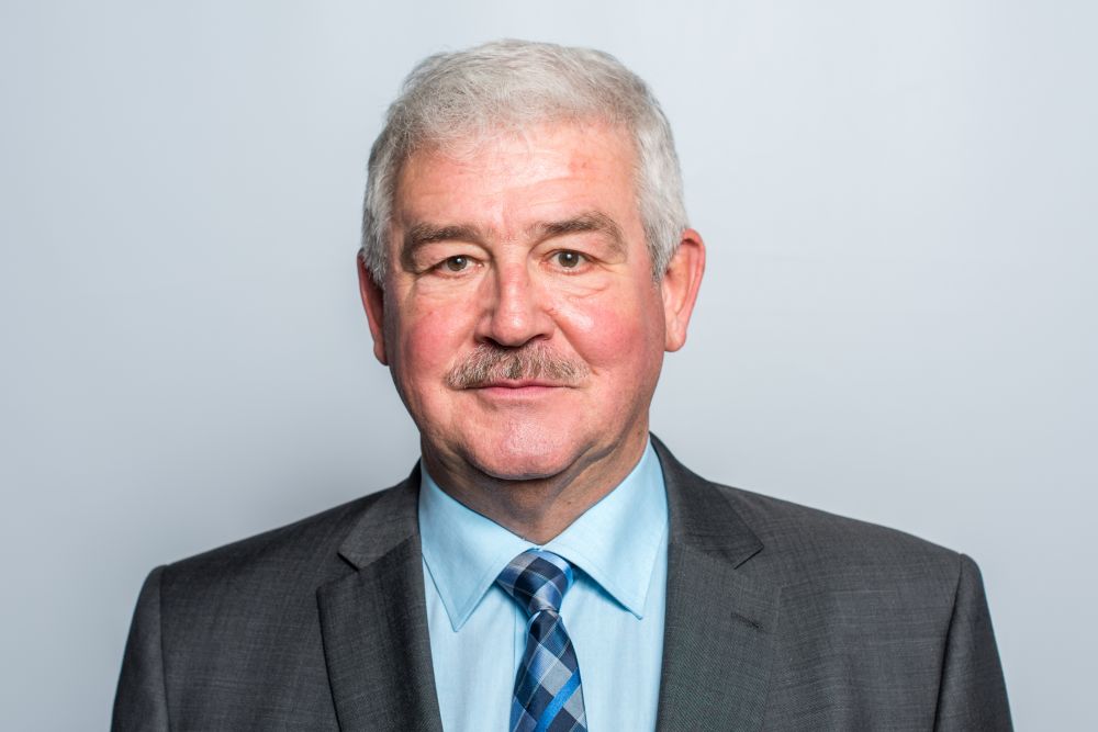 Portraitfoto. Älterer Mann mit hellem Hemd, Schlips und dunklem Anzug