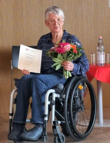 Prof. Dr. Sigrid Arnade mit Blumenstrauß und Ernennungsurkunde