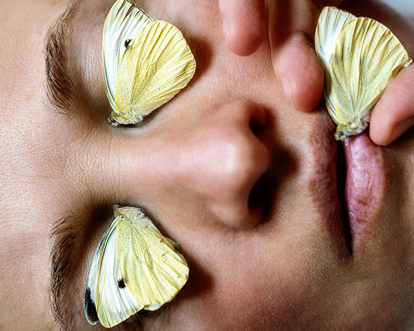 Schmetterlichge auf dem Gesicht einer Frau