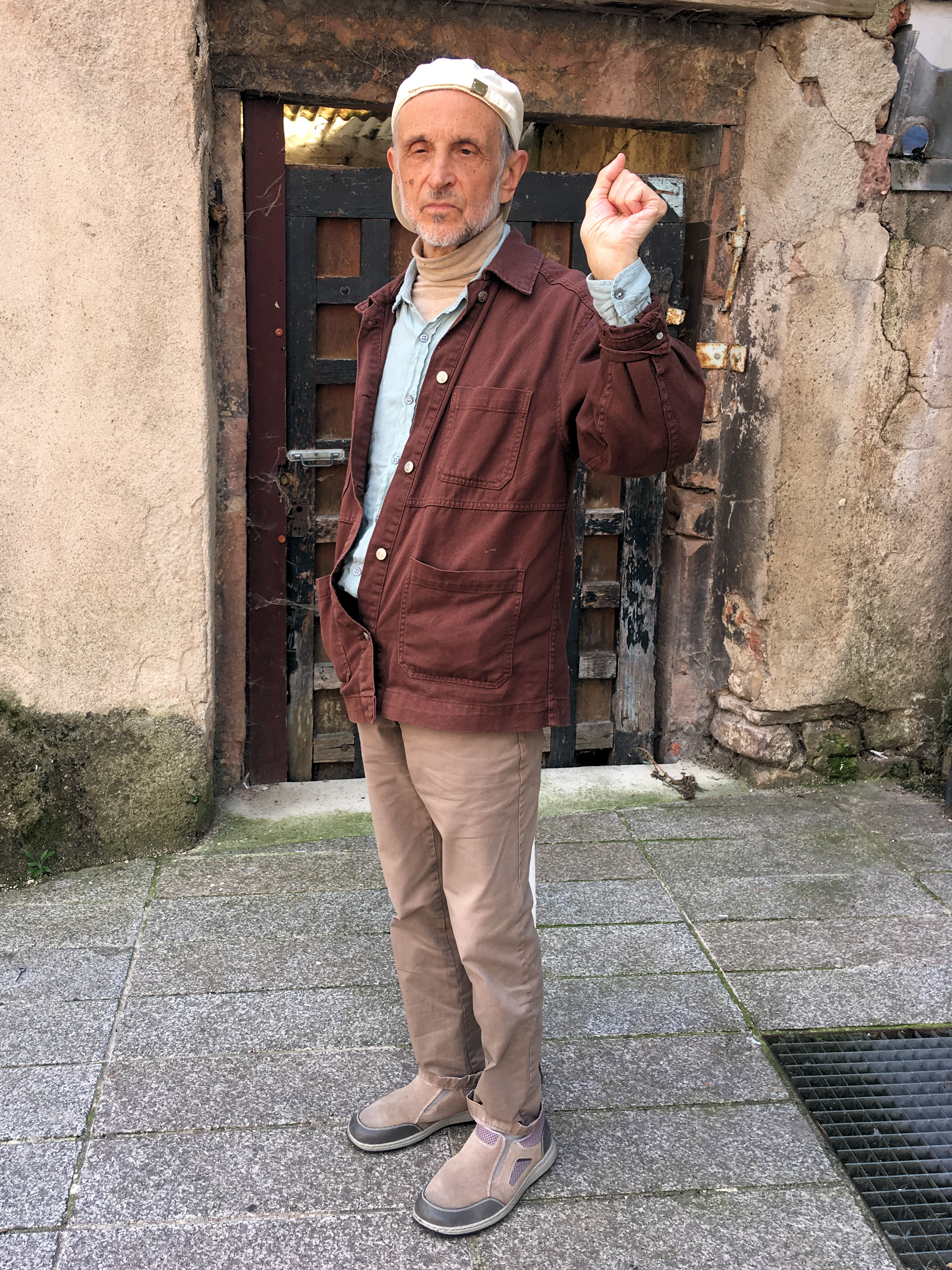 Hans-Willi Weis vor seiner Haustür mit erhobener linken Faust, dem Symbol der 68er