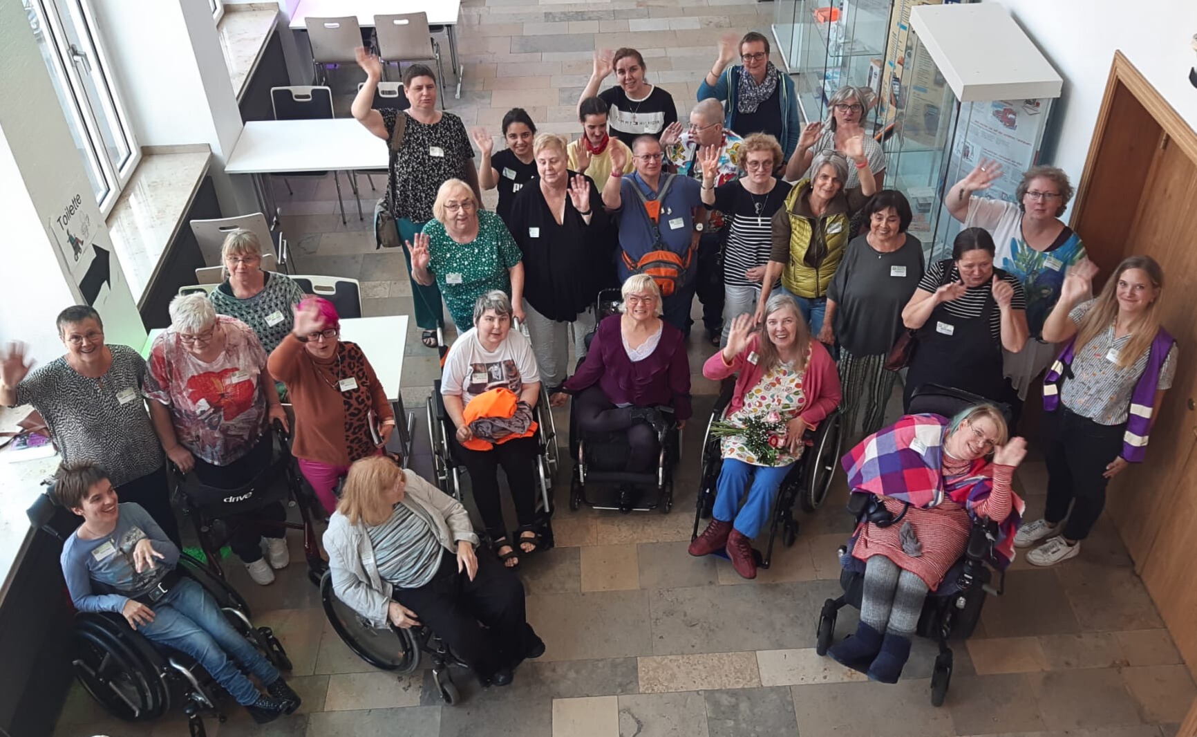 Blick von oben auf eine Gruppe von Frauen, von denen einige im Rollstuhl sitzen