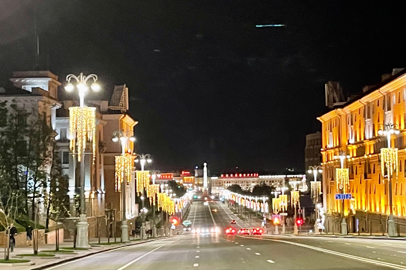 Breite Straße in einer hell erleuchteten Stadt mit vielen Lampen entlang der Straße