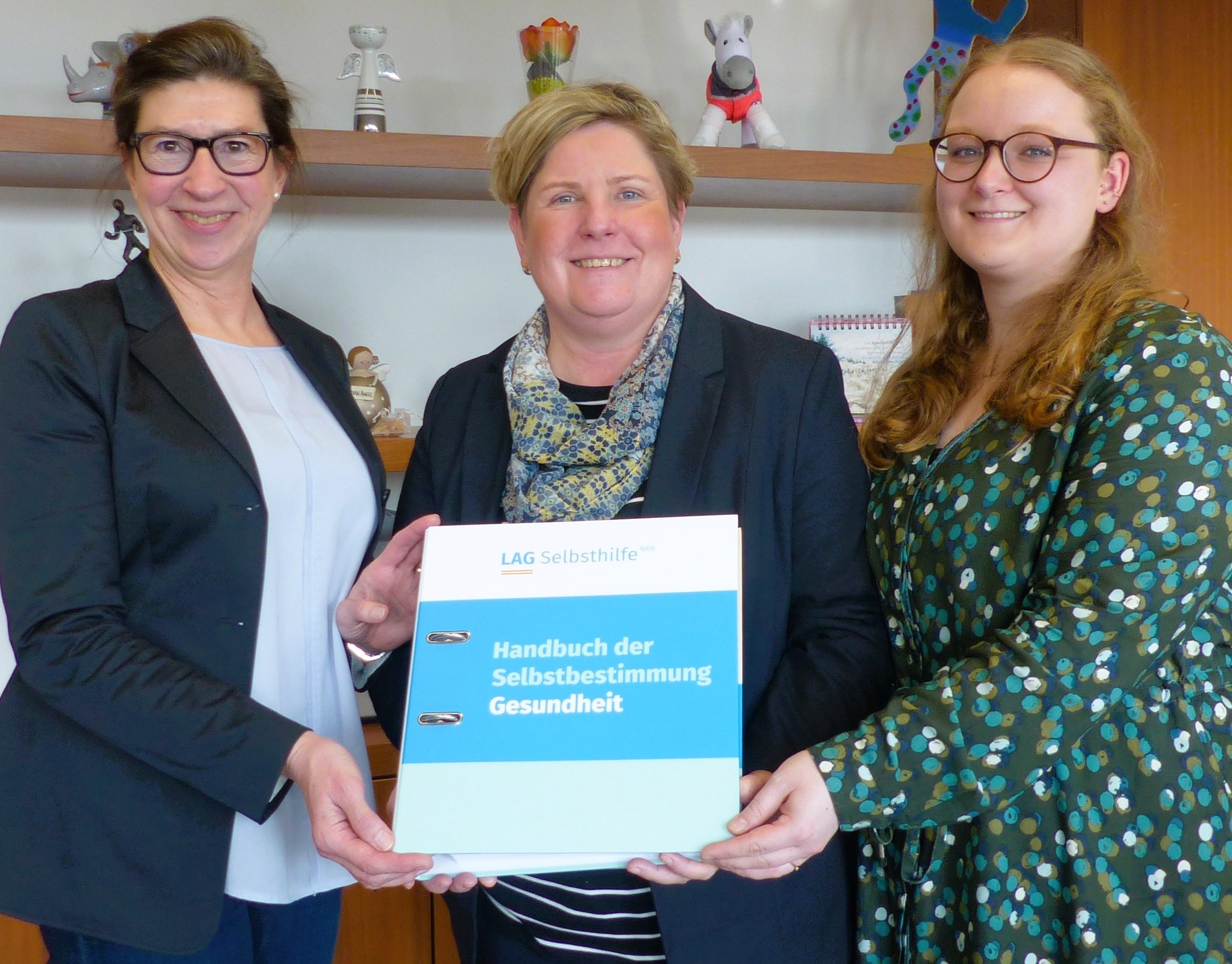 Drei Frauen haben ein Buch in  den Händen