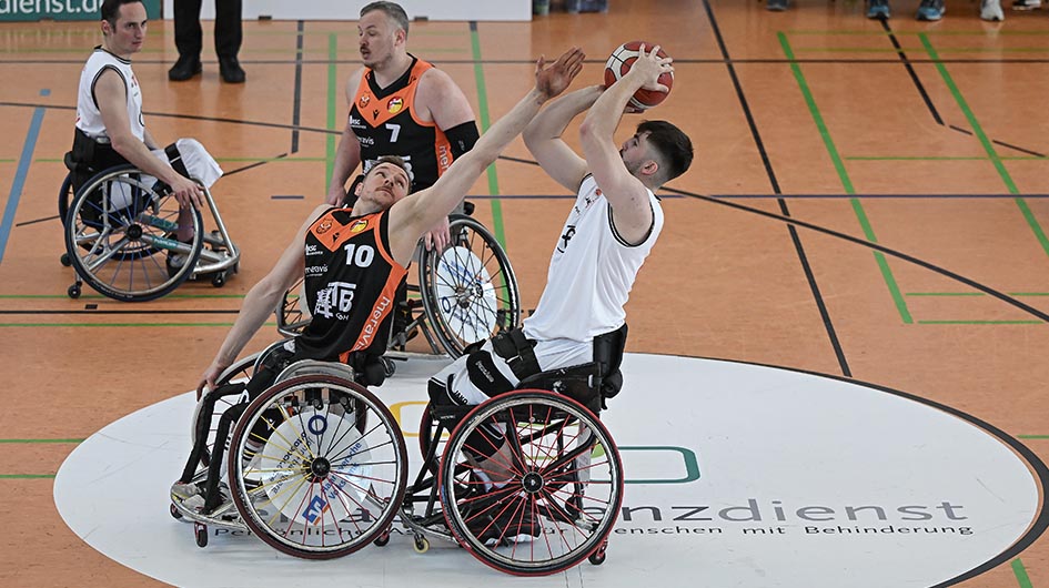 Jeweils zwei  Spieler gegenerischer Mannschaften bei. Ein Spieler ist dabei, den Ball zu werfen