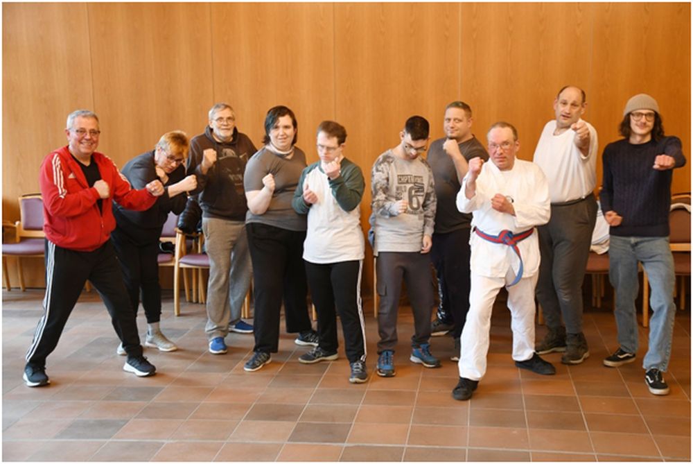 Sportlerinnen und Sportler auf einer Bühne in Kampfstellung