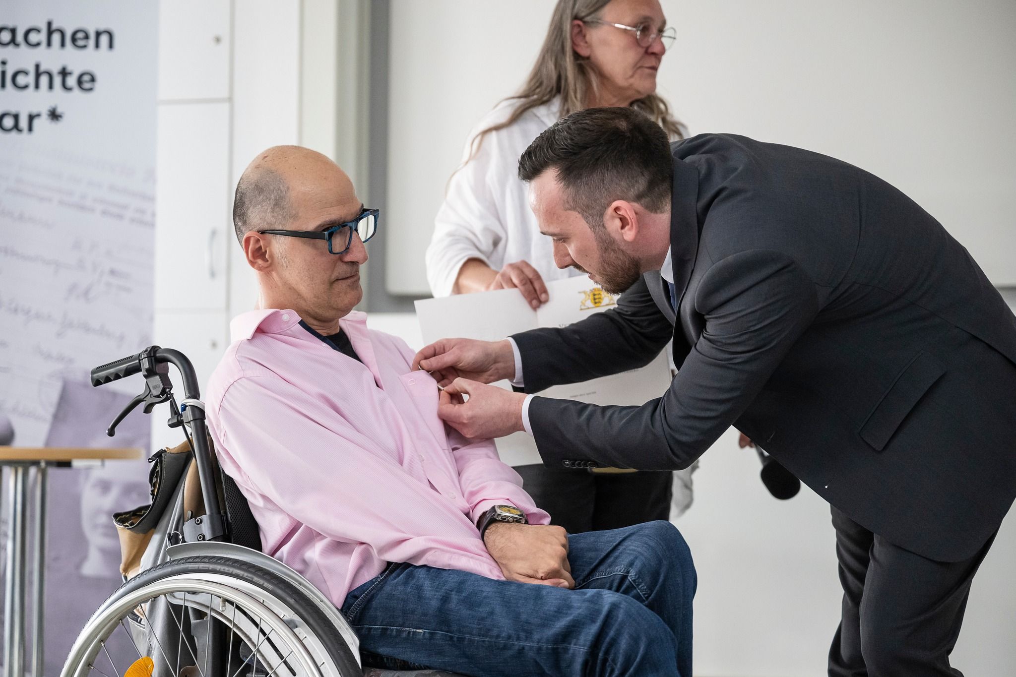 Antonio Florio wird die Ehrennadel des Landes Baden-Württemberg von Christos Vavouras angeheftet
