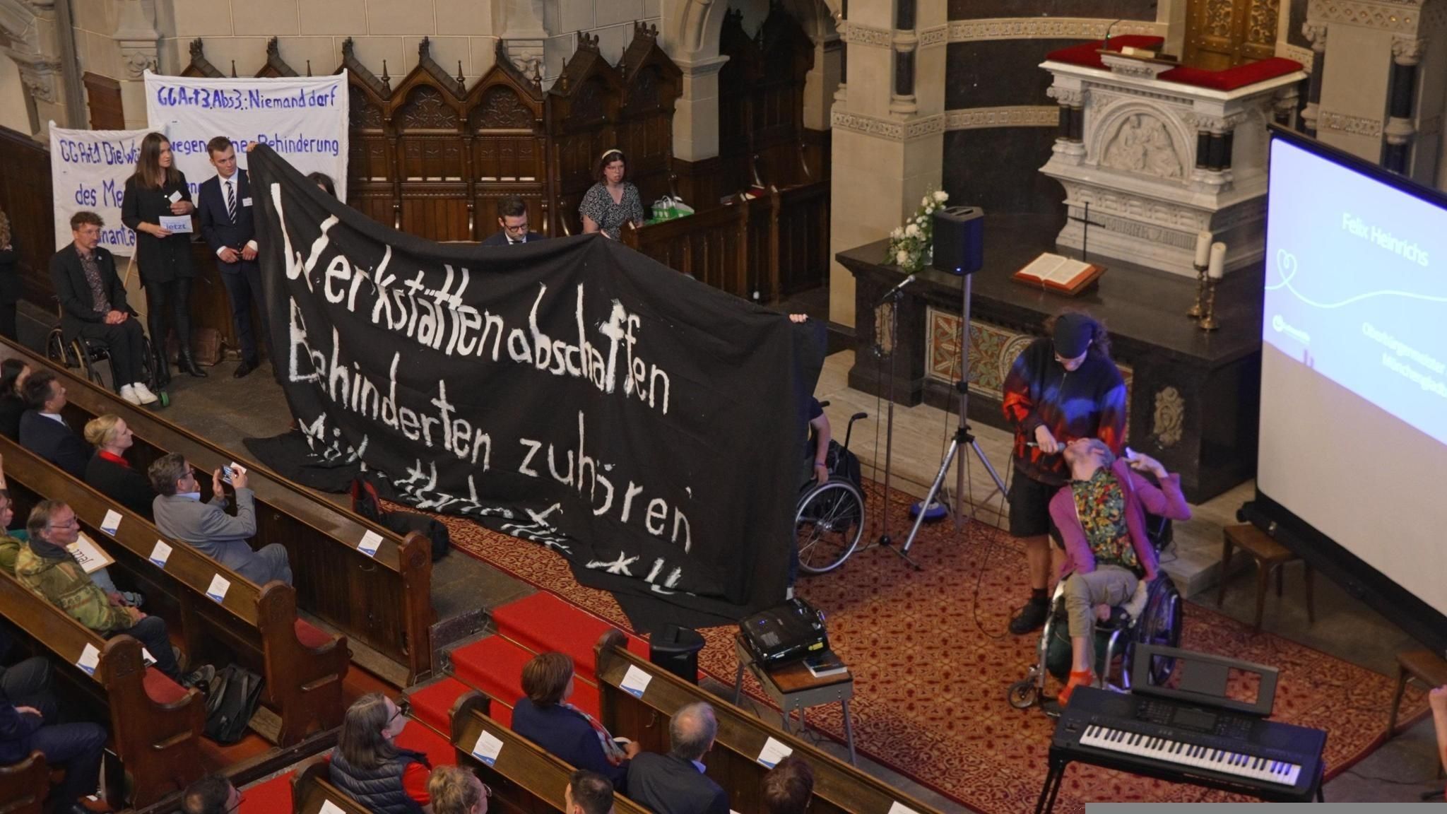 Bild von der Aktion von Fight Ableismus am 6. Juni mit Transparent in der Kirche