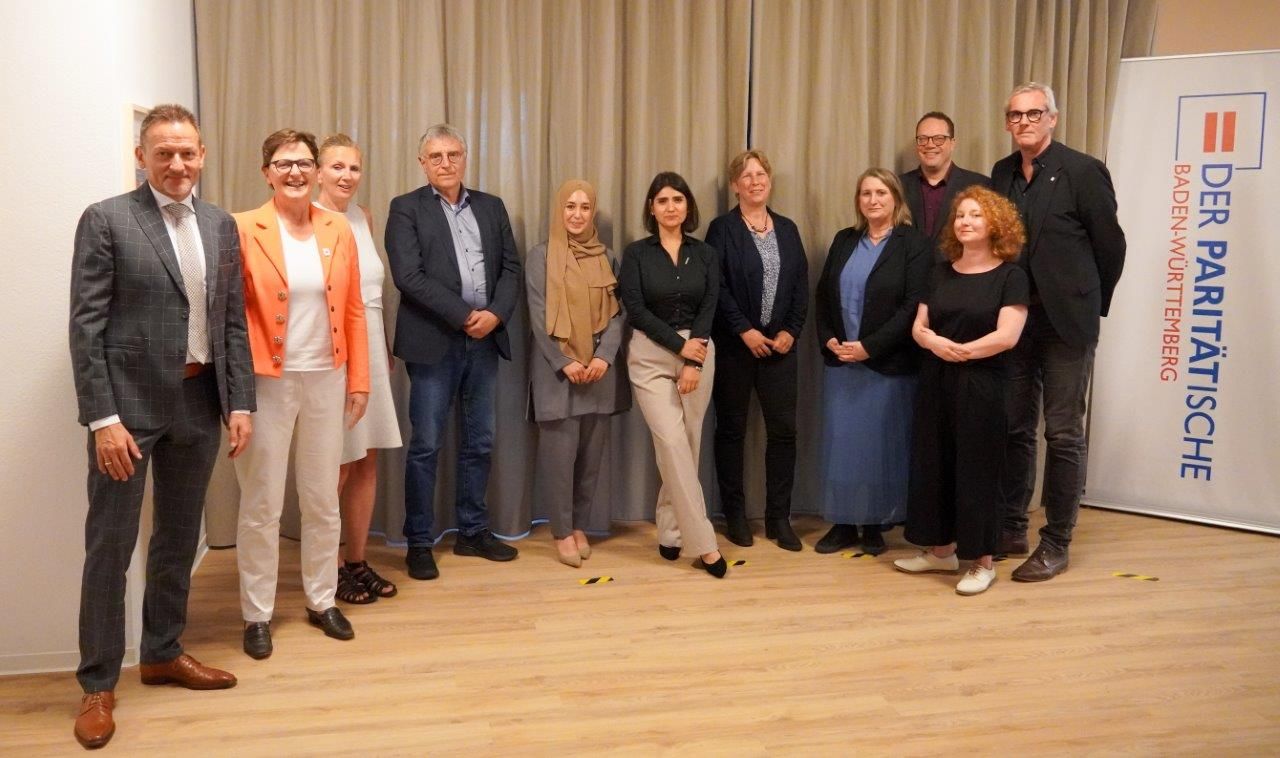 Gruppenbild mit elf Personen neben einer Tafel mit der Aufschrift Paritätischer Wohlfahrtsverband