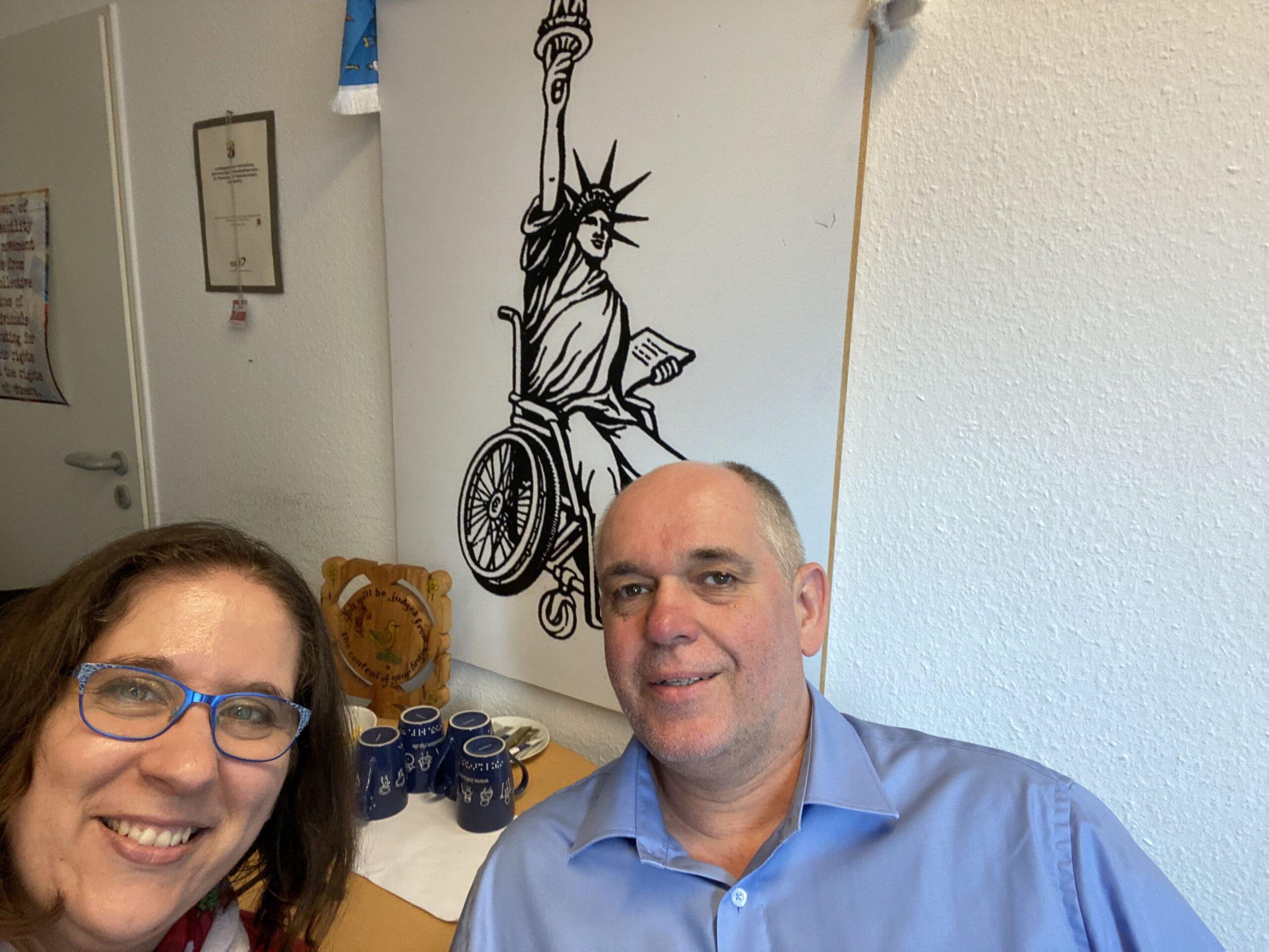 Ellen Kubica und Ottmar Miles-Paul vor Bild mit Freiheitsstatue im Rollstuhl