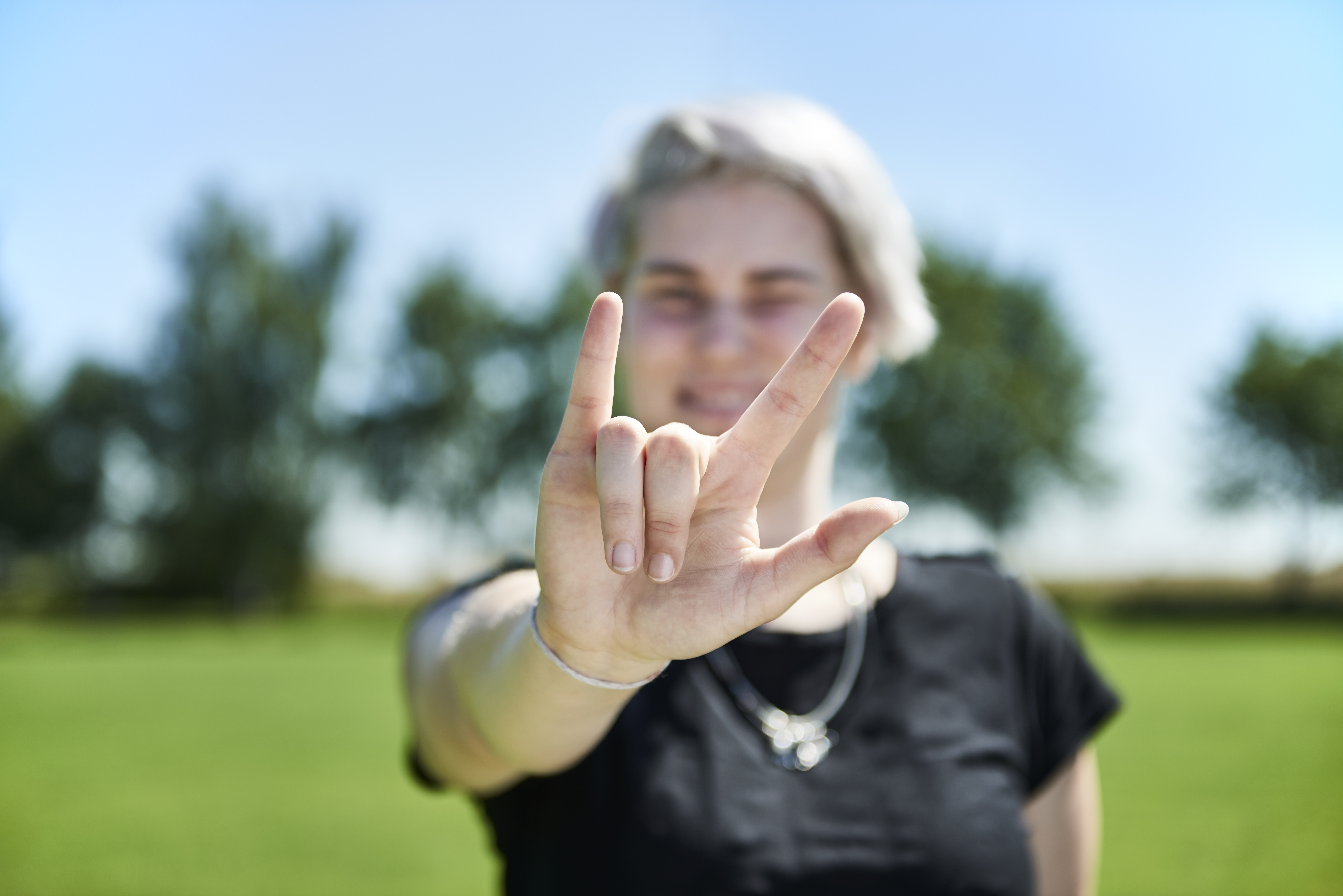 Eine Frau zeigt mit ihrer Hand die Buchstaben I, L und Y
