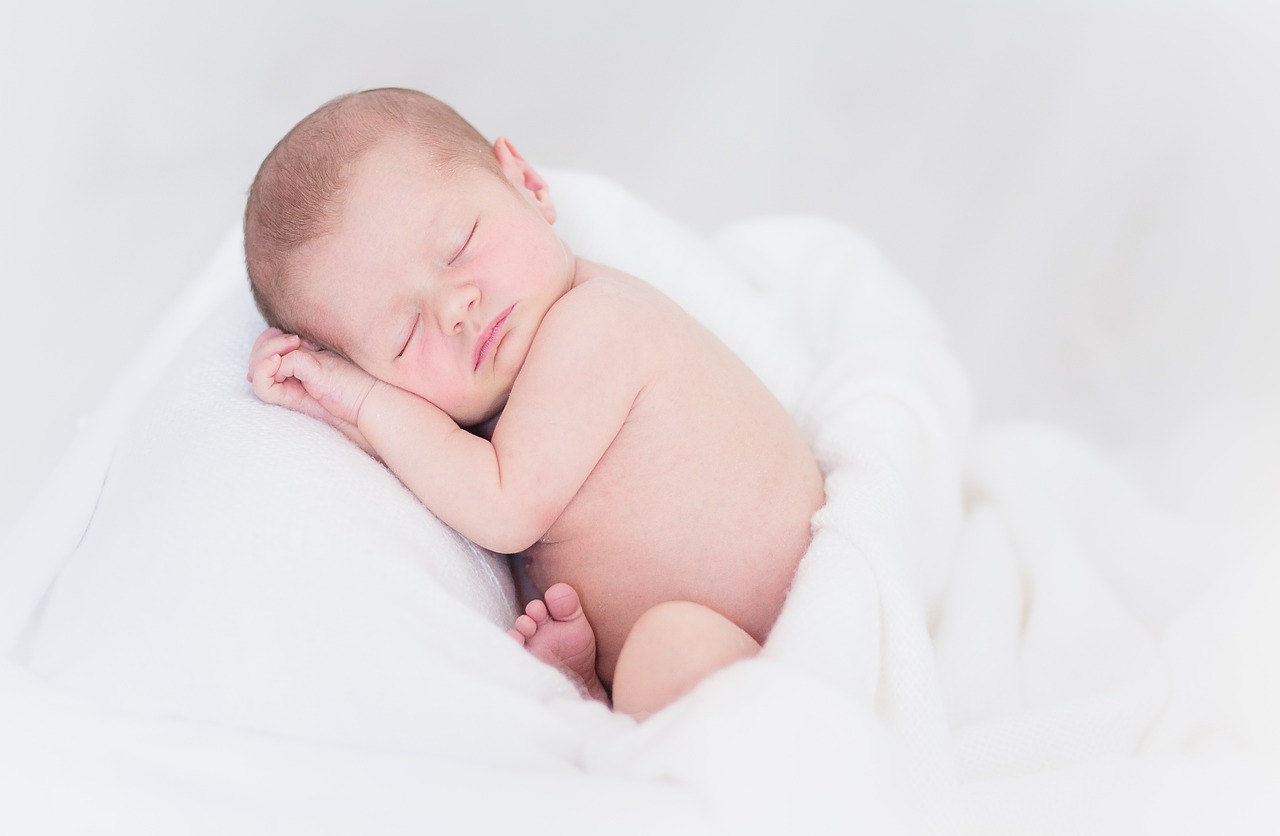 Bild eines in weißen Decken gehüllten schlafenden Babys