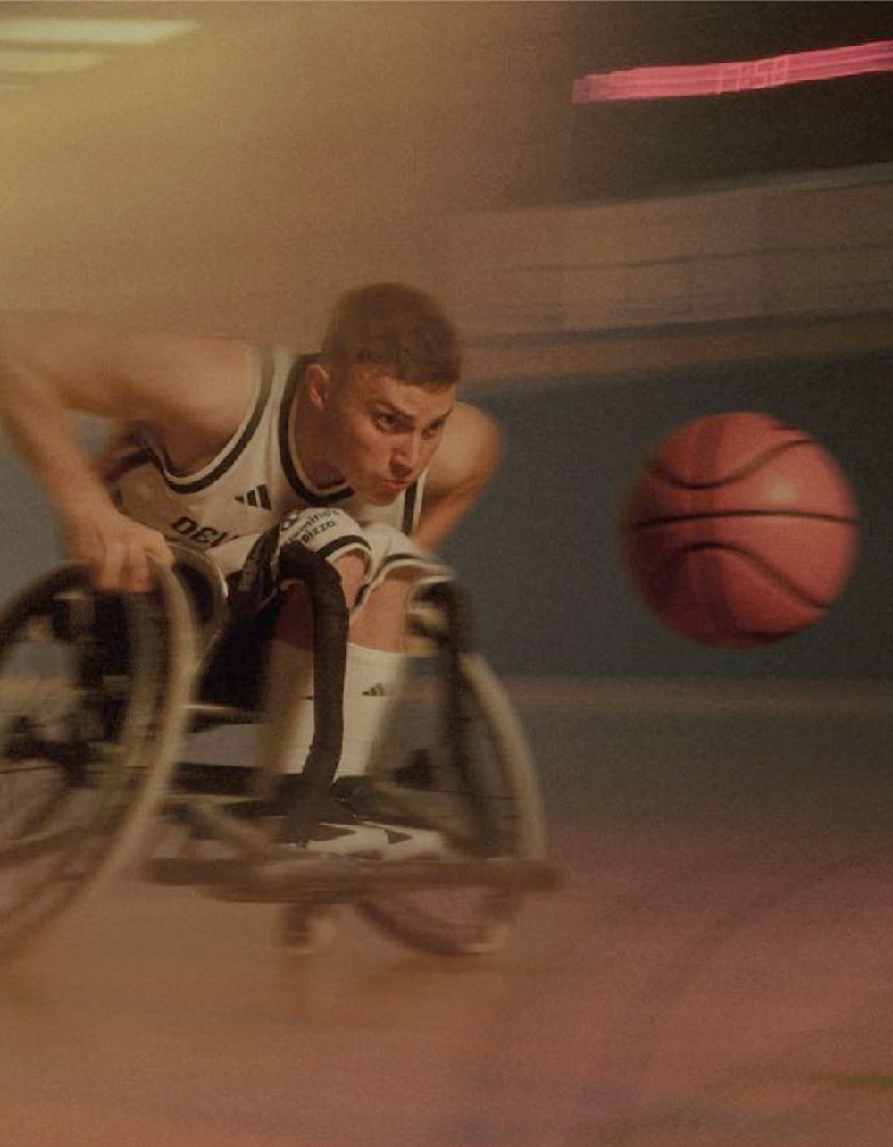 Mann im Sportrollstuhl, der in hohem Tempo auf einen Ball zufährt